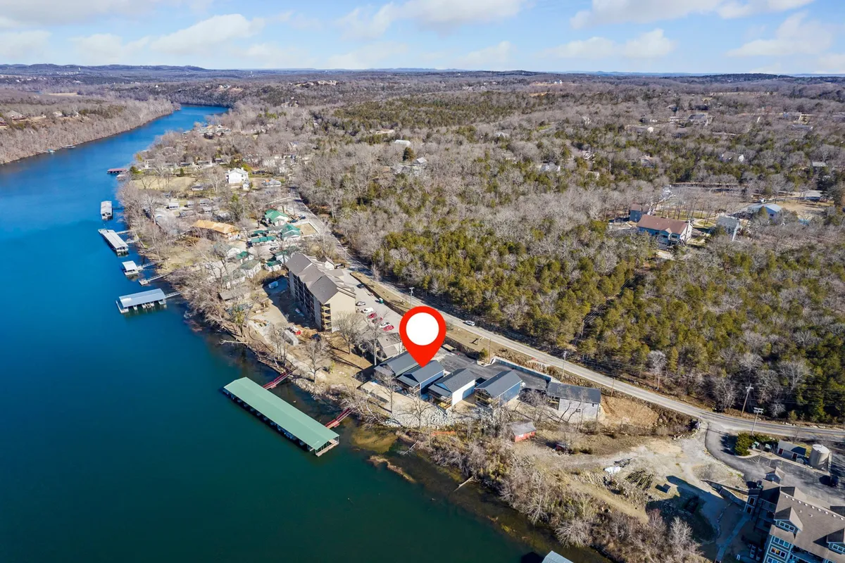 A gentle river bordered by vibrant greenery and charming boathouses, setting a relaxed mood that invites exploration and leisure activities by the water.