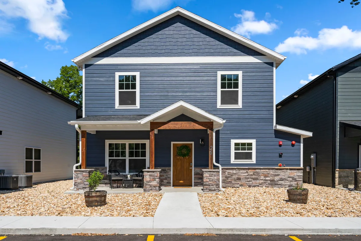 A welcoming view of the home’s main entrance and front porch, framed by attractive landscaping, suggesting comfort, hospitality, and a well-maintained property.