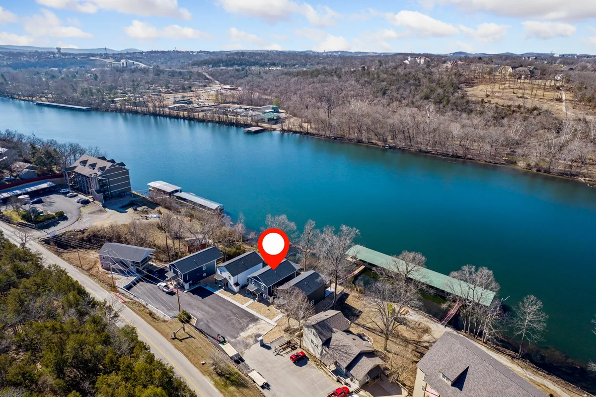 A tranquil riverside setting with houses and docks lining the shore. The calm water and natural surroundings suggest recreational opportunities and a peaceful environment for outdoor enjoyment.